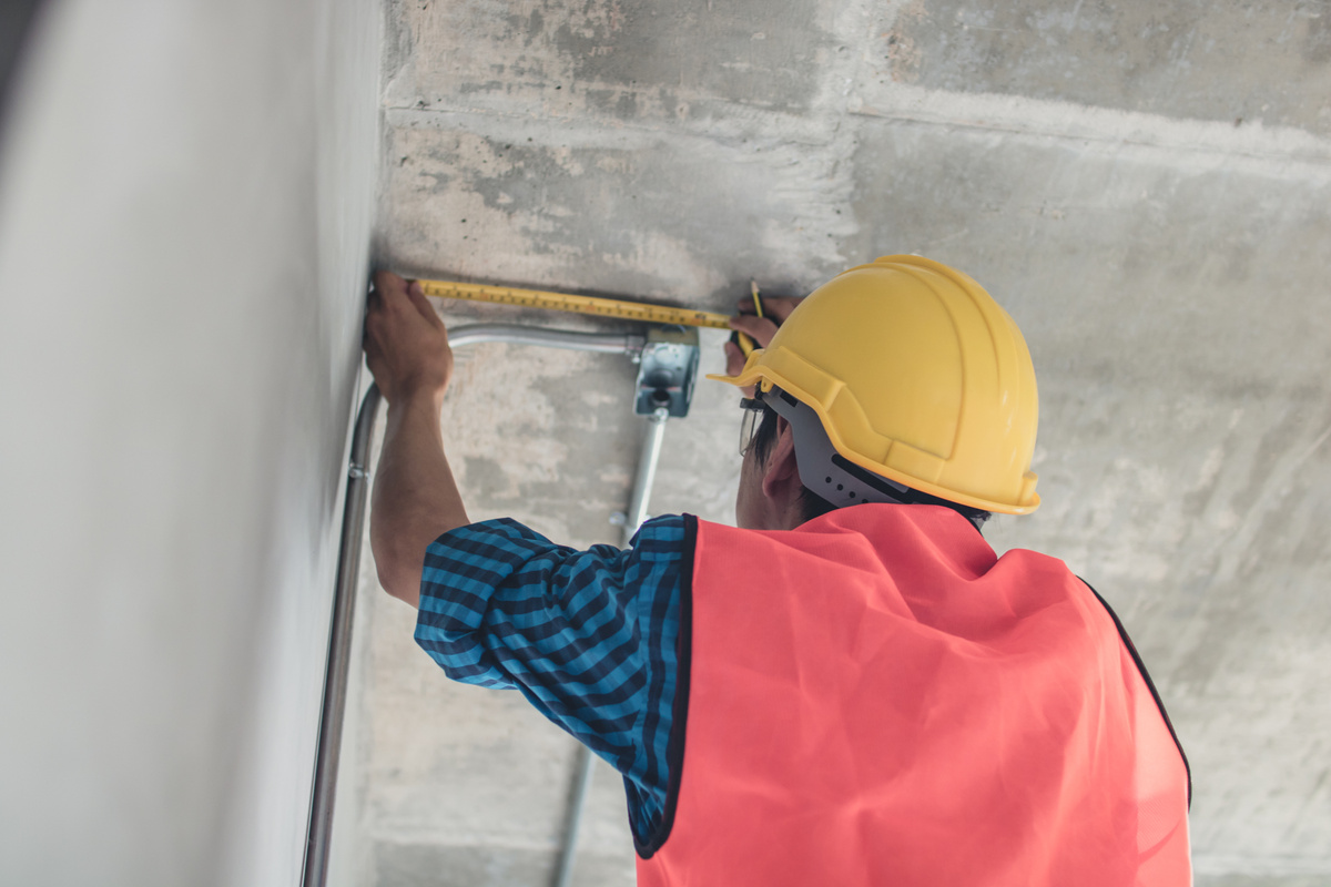 Electrician Use Measuring Tape to Measure Electrical Pipe in Ren
